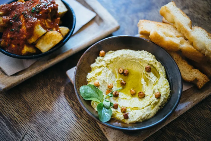 Hummus de albahaca con focaccia tostada y bravas